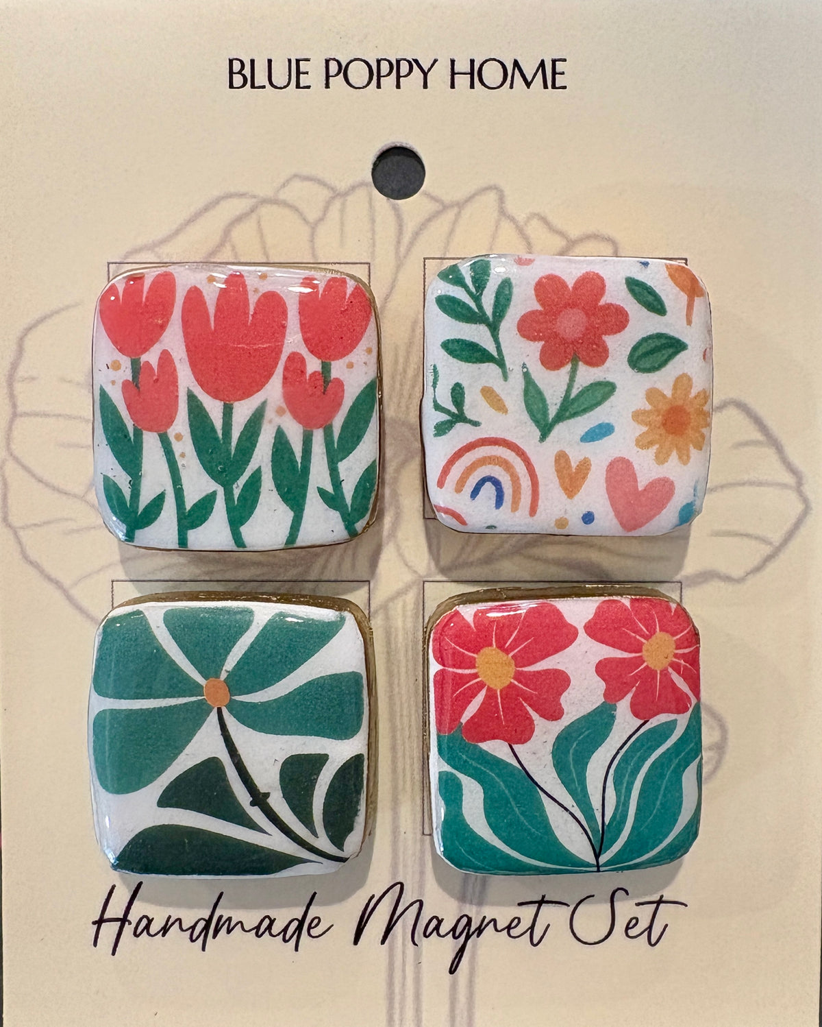 A set of four square handmade magnets with colorful floral and botanical patterns, displayed on a beige backing card labeled 'BLUE POPPY HOME' and 'Handmade Magnet Set'.